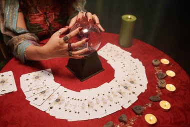 Geleceği tahmin etmek için kristal küre, tarot kartları ve rünler kullanıyor.