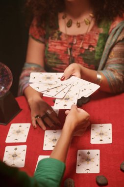 Kadın soru soruyor ve tarot kartını dağıtıyor.