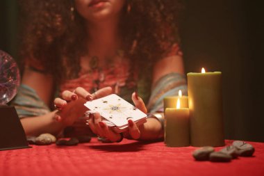 Gören kişinin tarot kartlarını karıştırıp istemci için dağıtırken yakın plan görüntüsü