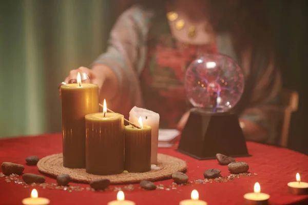 魔法师在她面前的桌上燃着巨大的蜡蜡烛的特写 — 图库照片