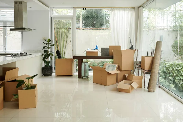 Cardboard boxes with packed belongings in house of relocating family