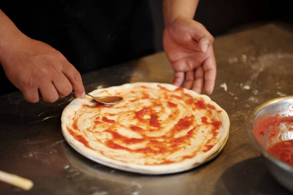 Крупный План Пиццамейкера Распространяющего Томатный Соус Тесто Пиццы — стоковое фото