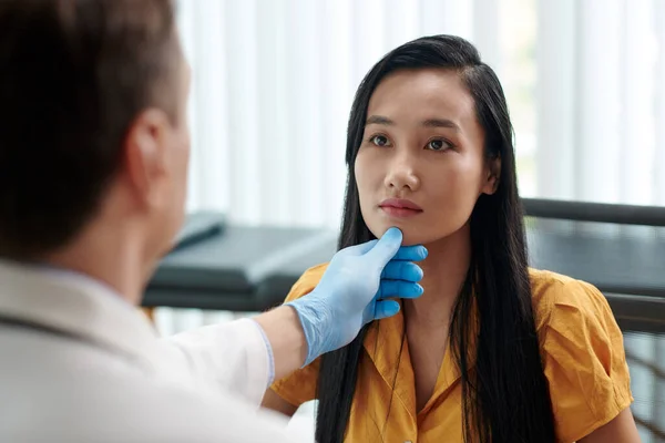 治療を推奨する前に女性の顔を検査するプラスチック外科医 — ストック写真