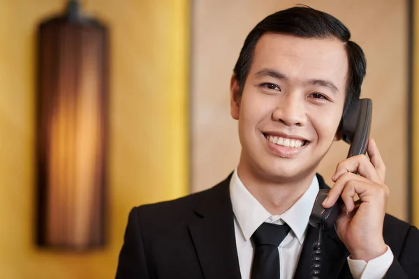 Spa resort manager talking on phone with guest and staff