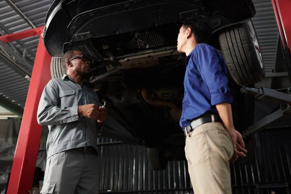 Car Owner Mechanic Standing Suspended Car Discussing What Needs Fixed — Stock Photo, Image