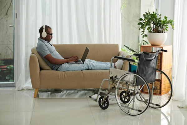 Uomo Con Disabilità Seduto Sul Divano Casa Che Lavora Gioca — Foto Stock