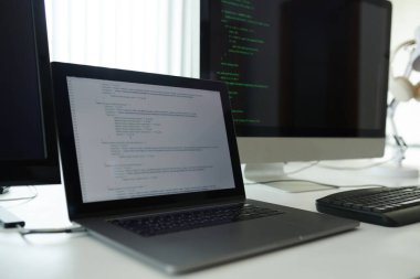 Yazılım geliştiricisinin masasında programlama koduyla açılan dizüstü bilgisayar