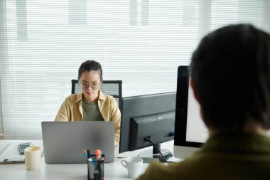 Ofis masasında laptopta çalışan düşünceli yazılım geliştiricisi