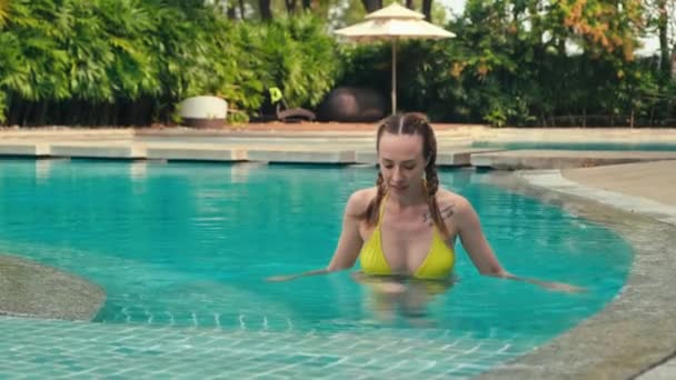 女性の休暇はプールを離れ トロピカルな場所の高級リゾートで休む — ストック動画