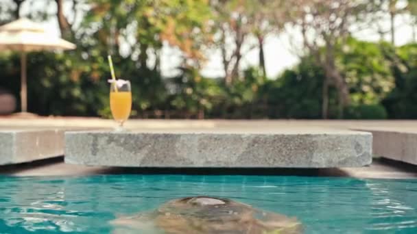 熱帯の休暇中にプールにいる間 水中から浮かぶ女性の背中の景色 — ストック動画