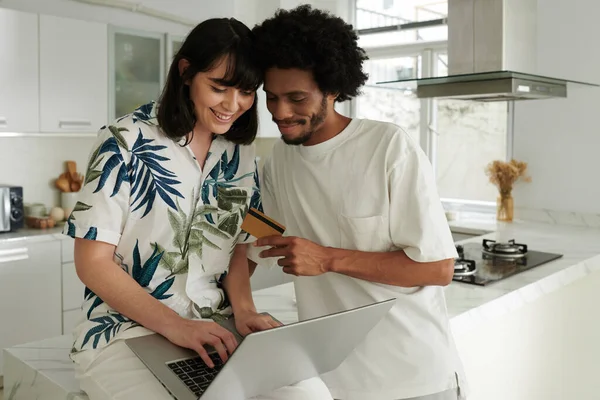 Fiatal Férfi Hitelkártyával Áll Felesége Mellett Gépel Laptop Billentyűzetén Miközben — Stock Fotó