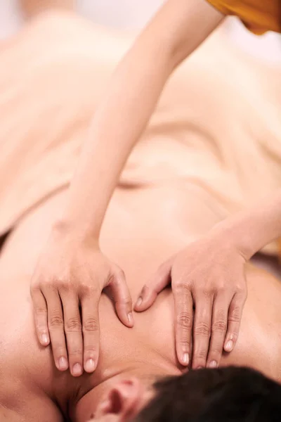 Сосредоточьтесь Руках Молодой Массажистки Спине Пациента Мужчины Лежащего Диване Салоне — стоковое фото