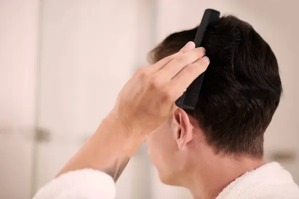 年轻男子用洗发水洗头并使用护发素后 用黑色塑料刷子梳理短短的黑发的侧视图 — 图库照片