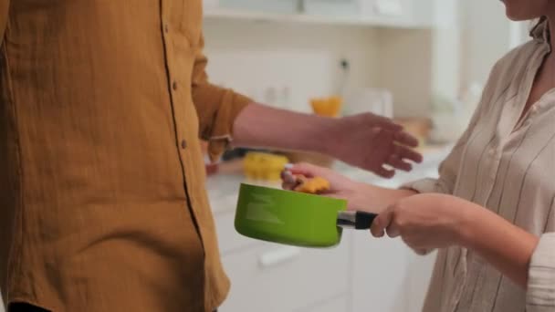 在厨房准备晚饭时 把妻子给丈夫的勺子和浓汤放在一起吃的镜头倾斜起来 — 图库视频影像