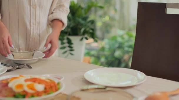 自宅でお祝いのディナーの準備をしている間 テーブルにプレートを供給する女性のクロップショット — ストック動画