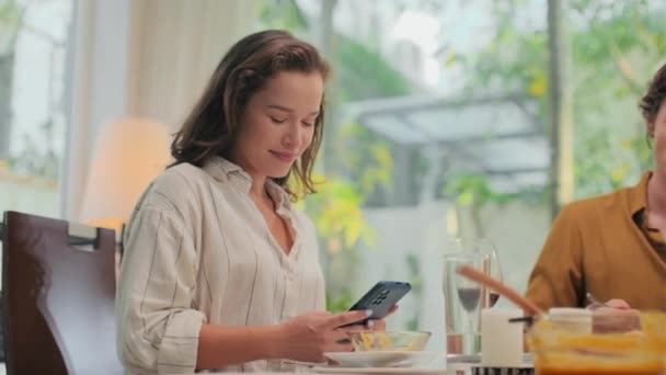 그녀의 남편과 테이블에 앉아서 집에서 식사를하는 전화에 사람을 메시지 — 비디오