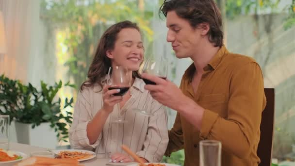 Średnie Ujęcie Młodej Pary Pijącej Czerwone Wino Szklanek Całującej Się — Wideo stockowe