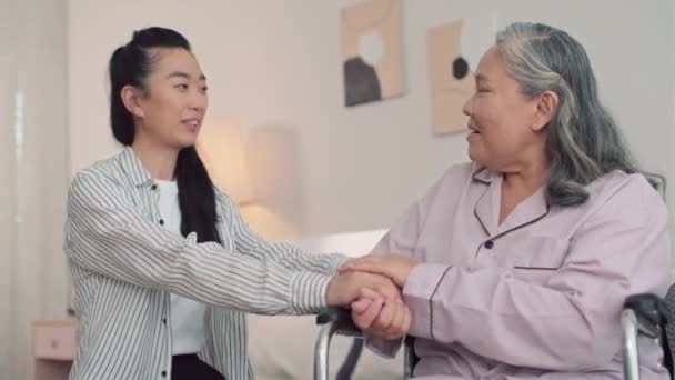 Средний Снимок Молодой Азиатки Поддерживающей Свою Мать Сидящую Инвалидном Кресле — стоковое видео