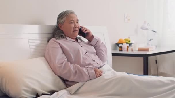 在卧床休息时 用手机打给丈夫的中位女性病人照片 — 图库视频影像
