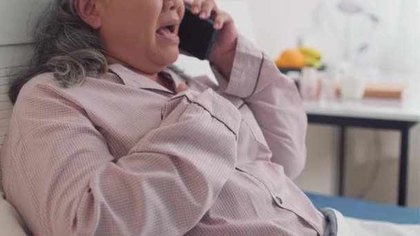 침대에서 휴식하는 치료에 스마트 의사를 호출하는 성숙한 아시아 여성의 기울이십시오 — 비디오