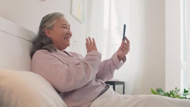 Πλευρική Άποψη Της Ηλικιωμένης Ασιάτισσας Που Μιλάει Φίλους Βιντεοκλήση Χρησιμοποιώντας — Αρχείο Βίντεο