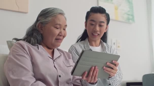 가정에서 그녀의 어머니를 디지털 태블릿에 동영상을 보여주는 여자의 — 비디오