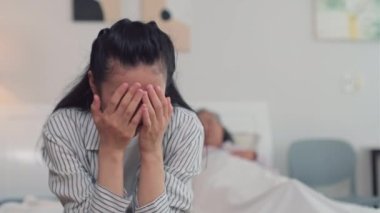 Asyalı kadın huzurevini ziyaret ederken annesinin hastalığı yüzünden ağlıyor.