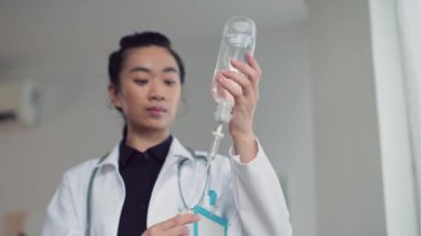 Genç Asyalı kadın doktorun hasta hasta için tezgah hazırlarken aşağı eğilin.