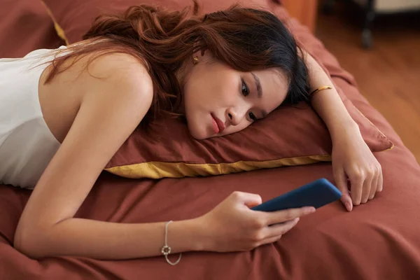 Депрессивная Молодая Женщина Лежит Постели Прокручивает Социальные Сети — стоковое фото