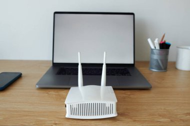 Wifi router açık dizüstü bilgisayarın önünde serbest çalışan birinin masasında.