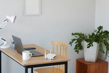 Bilgisayarlı masa, bir fincan kahve ve ofisteki kablosuz ağ yönlendirici.