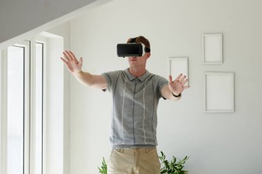 Sanal gerçeklik kulaklığıyla video oyunu oynayan genç adam