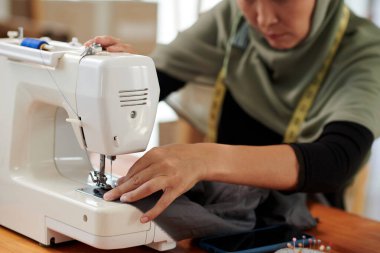 Müşteri sırasına göre çalışırken terzi dikiş makinesi kullanıyor