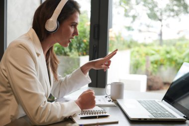 Ciddi bir kadın girişimci online toplantıda iş arkadaşına fikrini açıklıyor.