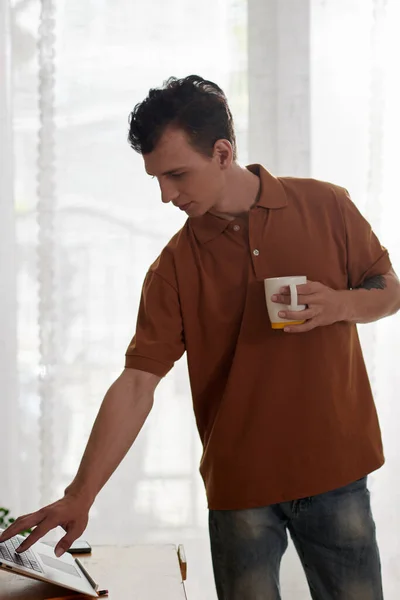 Social media manager uploading content on website when drinking morning coffee