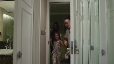 Anne, baba ve kızının aileleri tatil sırasında otele girerler.