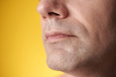 Tıraşlı, pürüzsüz tenli olgun bir adamın kırpılmış görüntüsü.