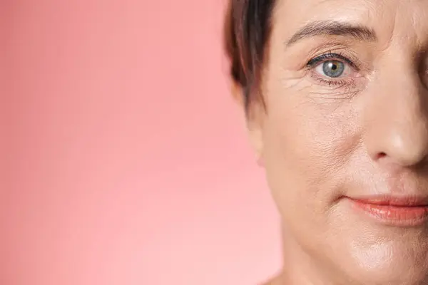 Face of mature woman with light makeup on looking at camera