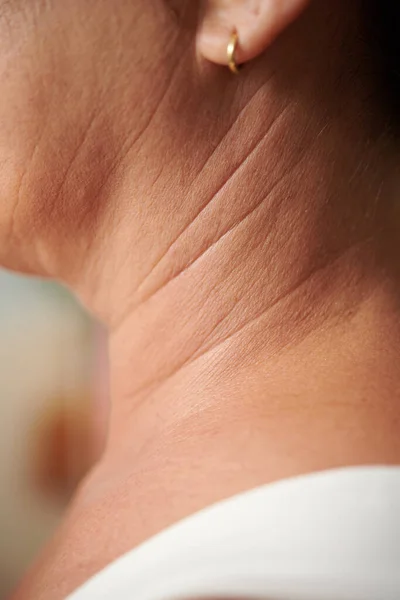 Wrinkles on neck of mature woman, aging and beauty concept