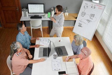 Bilgisayar sınıfı öğretmeni yeşil ekranlı akıllı telefon gösteriyor