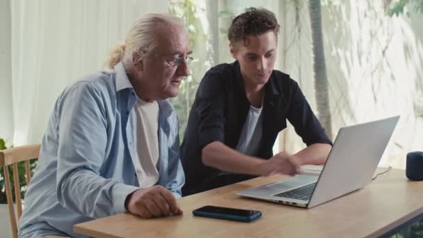 Mediana Toma Nieto Joven Mostrando Abuelo Cómo Utilizar Ordenador Portátil — Vídeo de stock