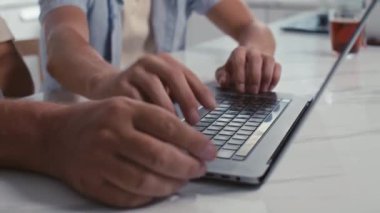 Genç oğlunun olgun babasına evde birlikte otururken kablosuz bilgisayarda mesaj yazmasını öğretirken görüntüsünü kaldır.