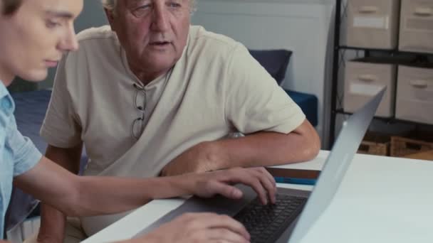 Medium Shot Young Man Helping His Retired Father Typing Information — Stock Video