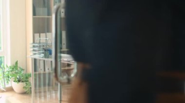 Müdürün ofisteki iş yerine gelip çantasını masaya koyduğu orta boy bir fotoğraf.