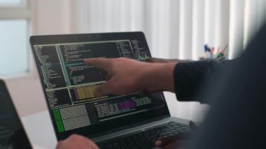 Yeni kodu tartışan, dizüstü bilgisayardan bakıp ekranı işaret eden tanınmayan programcıları kapatın.