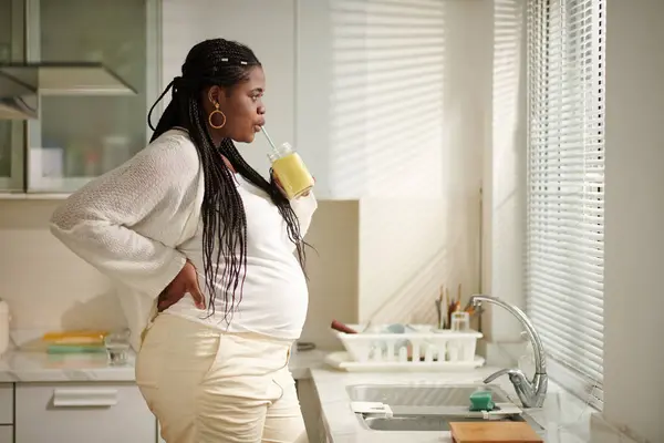 Mujer Embarazada Tomando Batido Para Desayuno Mirando Través Ventana Cocina — Foto de Stock