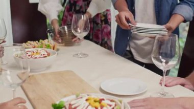 Kutlamaya hazırlanırken, tanınmayan insanların sofrayı şenlik yemekleriyle kurdukları sahneler.