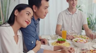 Asyalı çiftin pizza ve makarnayla yemek yemesine evde arkadaşlarıyla oturmasına odaklan.