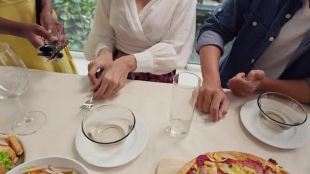 お祝いのテーブルに座っている人々にスプーンやフォークを与える認識できない女性の高角度ビュー — ストック動画