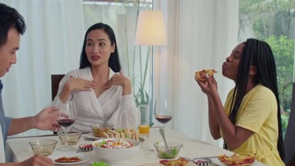 Amigos Multirraciais Comendo Pratos Bebendo Vinho Conversando Enquanto Sentam Juntos — Vídeo de Stock
